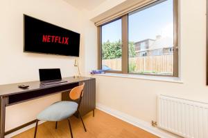 YiewsleyPrime Luxury, Heathrow, FreeParking, WiFi, Netflix的客房设有一张带笔记本电脑和窗户的书桌。