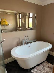 MartonCherry blossom lodge的浴室设有白色浴缸及镜子
