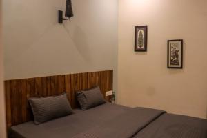 普里Tavāsmi的一间卧室配有一张带木制床头板的床