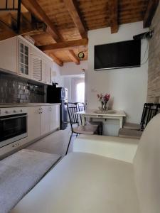 扎达尔Mini Villa Punta的厨房配有桌子,墙上配有电视。