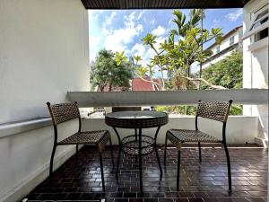 曼谷Oasis townhouse in the perfect location的阳台的天井配有桌椅