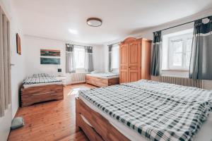 NiemthalHüdahof Niemtal的一间卧室设有两张床、木地板和窗户。
