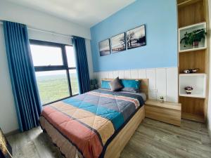 兴安Skylux homestay Ecopark Hung Yen的一间卧室配有一张蓝色墙壁的床和一扇窗户