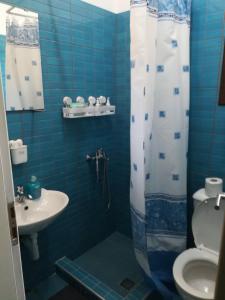卡拉内拉Vasileiou的蓝色瓷砖浴室设有卫生间和水槽