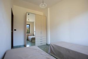 贝尔韦代雷Przytulny apartament w Belvedere Marittimo的一间卧室配有两张床和镜子