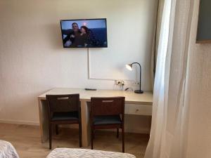 阿维尼翁Appart'Hotel - Gare TGV - Courtine - Confluence - 407的客房设有一张桌子、两把椅子和一台墙上的电视