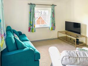 利普胡克Garden Cottage 2 - Uk42882的客厅配有蓝色的沙发和电视