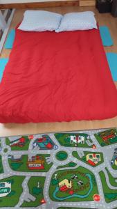 勒芒Magnifique maison à 5 mns du circuit des 24h à pieds的一张铺在地板上,带红色床罩的床