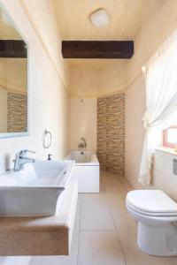 Il-PerglaInzolia - Peaceful Villa with Pool的浴室配有盥洗盆、卫生间和浴缸。
