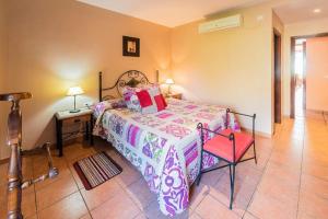 VillamielRestaurante & Casa Rural Boada的一间卧室配有一张床和一张红色椅子