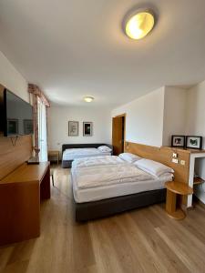波斯科米拉拉戈酒店的一间卧室配有两张床、一张桌子和一台电视。