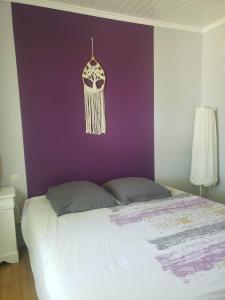马雷讷Chambre Zen à la campagne的一间卧室配有一张紫色墙壁的床