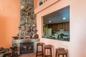 VillamielRestaurante & Casa Rural Boada的客厅设有壁炉和2张凳子
