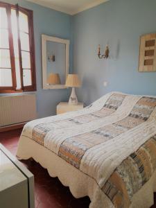 阿尔勒La maison de Toinette的一间卧室配有一张床、一盏灯和一面镜子