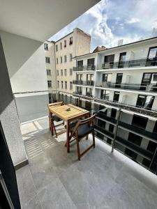 布达佩斯Cityscape Apartment ~ AC/Indoor parking/Balcony的阳台配有木桌和长凳