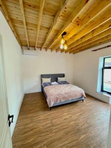 盖贝莱EMIREST Barnhouse的一间卧室设有一张床和木制天花板