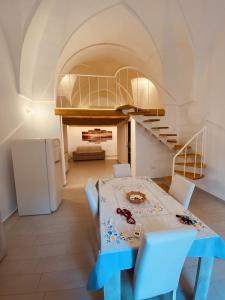 马蒂诺Family Deluxe Suite Salento的厨房以及带桌子和楼梯的用餐室。
