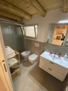 马蒂诺Family Deluxe Suite Salento的一间带卫生间、水槽和镜子的浴室