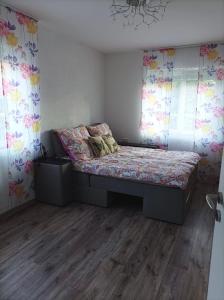 珀丽Wehr Orchidee Apartment的一间带床的卧室,位于带窗帘的房间