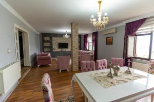 特拉布宗Villa Fatma的一间带桌子和粉红色椅子的用餐室