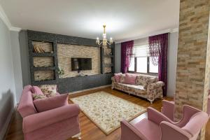 特拉布宗Villa Fatma的客厅配有粉红色的椅子和电视