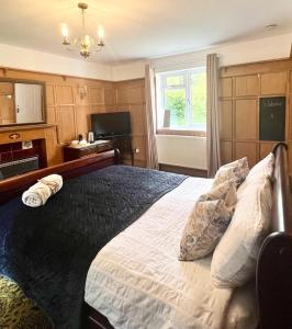 巴顿尼德伍的Canalside Cottage的一间卧室设有一张大床和一个窗户。