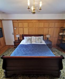 巴顿尼德伍的Canalside Cottage的一间卧室配有一张带蓝色被子的床和两盏灯。