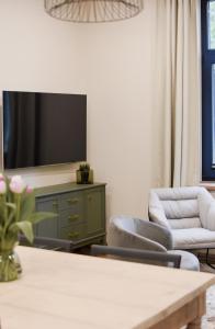 维尔扬迪Vaksali Apartment!的客厅配有两把椅子和电视