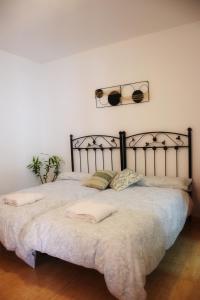 El RobledoRetiro del Bullaque的一间卧室配有一张大床和金属床头板
