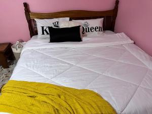 KerichoRuth's Studio - Kericho的一张白色的床,上面有黑色和黄色的毯子