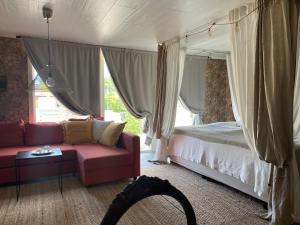 巴斯塔德Pia’s Country House的一间卧室配有一张床、一张沙发和一个窗口