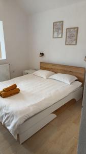 OgradenaCasa colț de rai的卧室配有一张白色大床和木制床头板