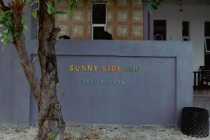 MiduSunny Side inn的一面墙,上面有读阳光明媚的一面的标志