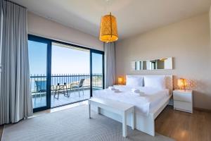 亚力卡瓦克Bovilla Hotel Yalıkavak的一间带一张白色大床的卧室和一个阳台