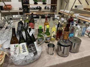多治见市Kuretake Inn Premium Tajimi Ekimae的一张桌子上放着许多瓶酒