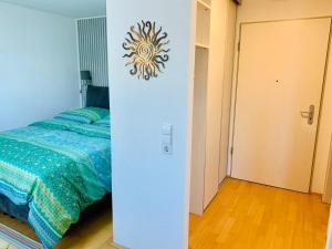 卡尔斯鲁厄AnNa Home & Sunny Home Apartments的一间卧室配有一张床,墙上配有时钟