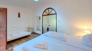巴贝Las Fincas Baabe的一间白色卧室,配有两张床和镜子