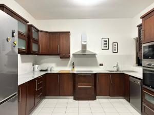 Il- GżiraGalileo Rooms的厨房配有木制橱柜和白色瓷砖地板。