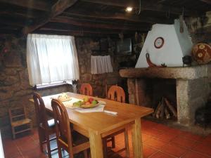 瓜尔达Quinta Do Quetrofe的带壁炉的客房内的一张木桌和椅子