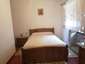 瓜尔达Quinta Do Quetrofe的一间卧室设有一张木床和一个窗户。