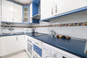 阿尔么丽亚La Casa Verde的厨房配有白色橱柜和蓝色台面