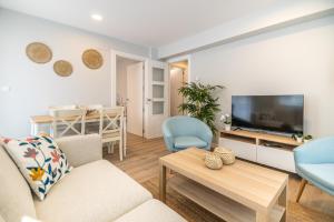 乌迪亚莱斯堡VILLA MARTA - Apartamentos céntricos junto al mar的客厅配有沙发和桌子