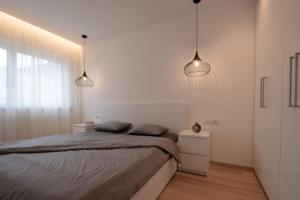 坎波图雷斯Casa Pina Campo Tures的一间卧室配有2盏吊灯和1张床