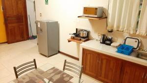 伊基托斯102 RV APARTMENTS IQUITOS-APARTAMENTO FAMILIAR CON PISCINA的厨房配有桌子和冰箱