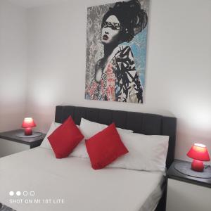 扎博里克Apartment T&T Žaborić的一间卧室配有一张带红色枕头的床和一幅画