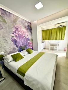 杜布罗夫尼克罗马拉公寓的一间卧室配有一张带花卉壁画的大床