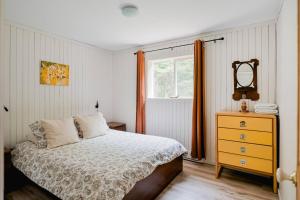 MansonvilleChalet Memphrémagog (Spa, étang, golf)的一间卧室配有床、镜子和梳妆台