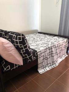 马尼拉Kasara Urban Resort and Residences的床上有黑白毯子