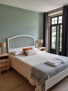 吉尔斯Villa Dos Santos - Gerês Country House的卧室配有白色床、两盏灯和一扇窗户。