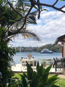 悉尼Newly Reburbished Sydney Harbourfront Boathouse Escape的一个带桌子和水中船只的庭院